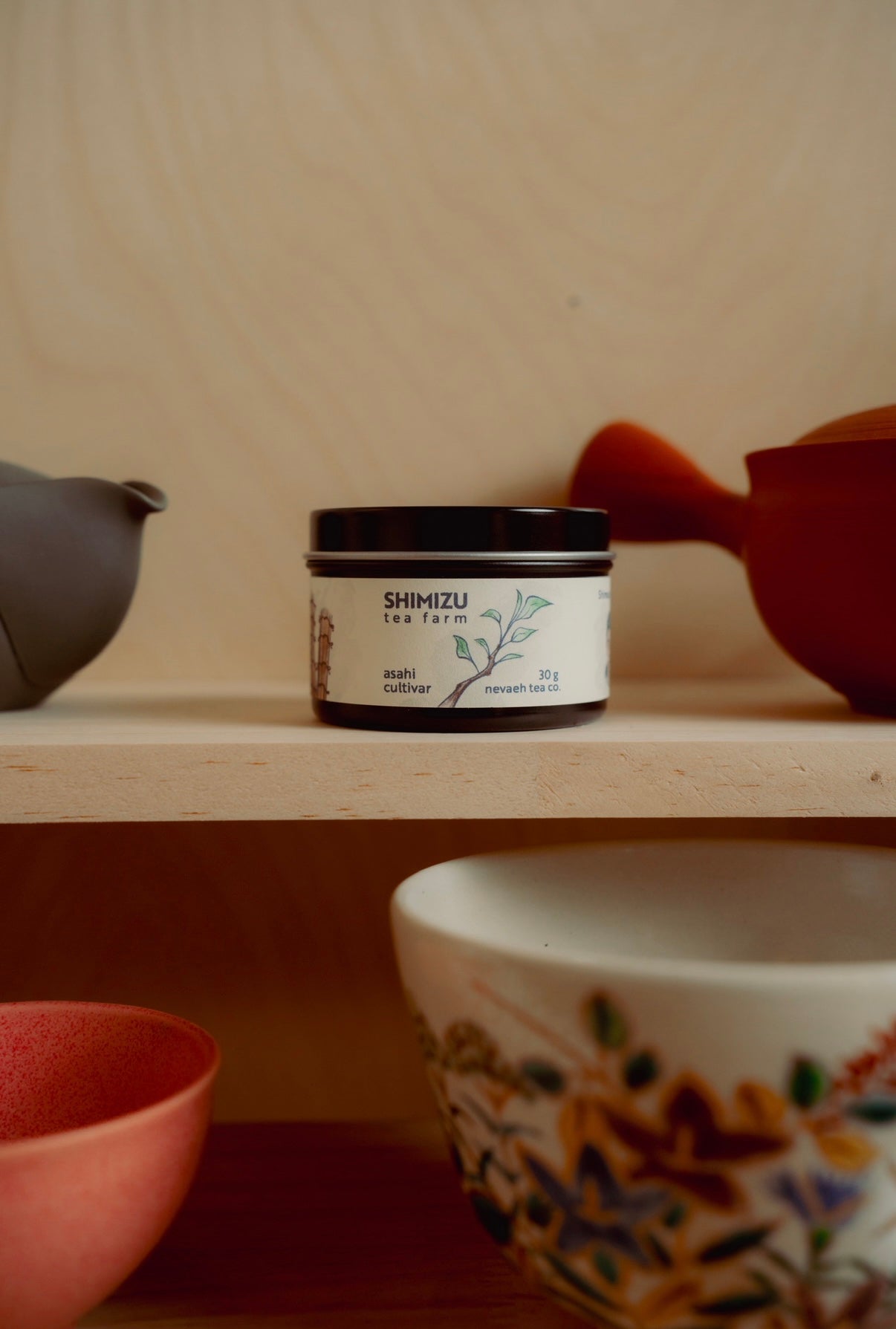 Jar of Shimizu tea on a wooden shelf with ceramic items