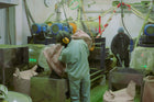 Person working in a factory setting with machinery and equipment.