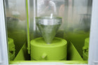 Green machine with a funnel-like component inside a transparent enclosure